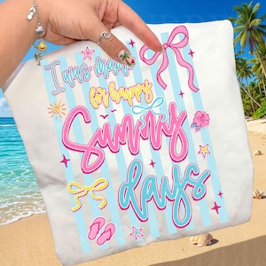 May include: White tote bag with the text "I was made for happy sunny days" in pink, yellow, and blue. The design includes stripes, bows, stars, and flip-flops. The background shows a beach scene with palm trees.