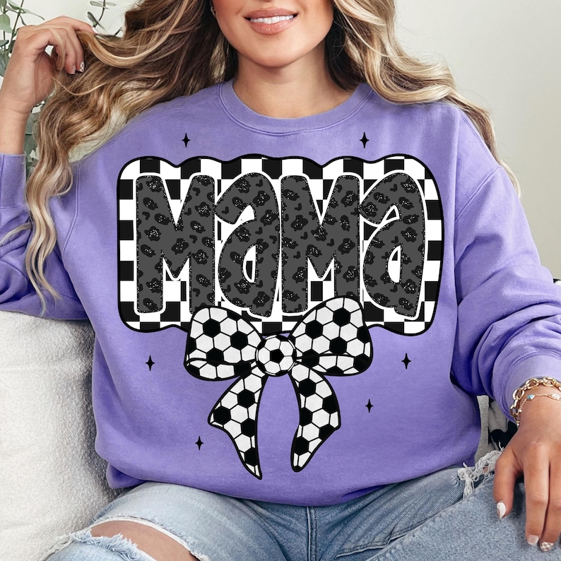 May include: Purple sweatshirt with a black and white chequered design and the word "Mama" in black with a leopard print pattern. A black and white football bow is below the word.