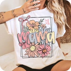 May include: White t-shirt with a floral design and the word "mama" in colorful letters.