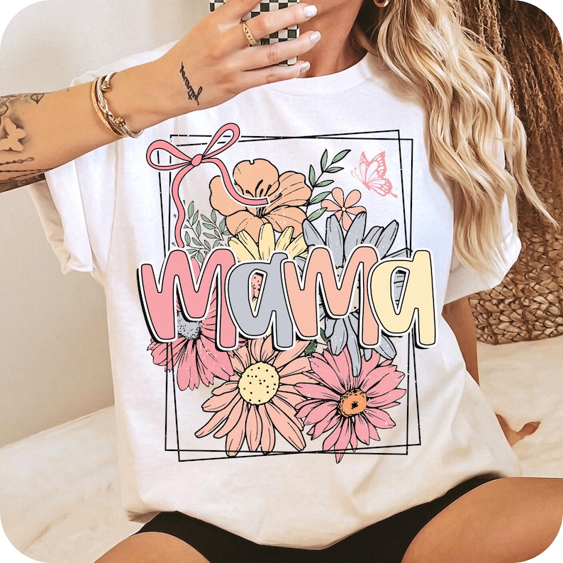 May include: White t-shirt with a floral design and the word "mama" in colorful letters.