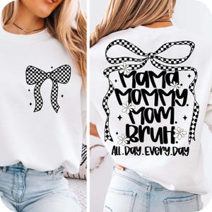 May include: White sweatshirt with a black and white checked bow on the front and a black and white checked bow with the text "Mama. Mommy. Mom. Bruh. All. Day. Every. Day." on the back.
