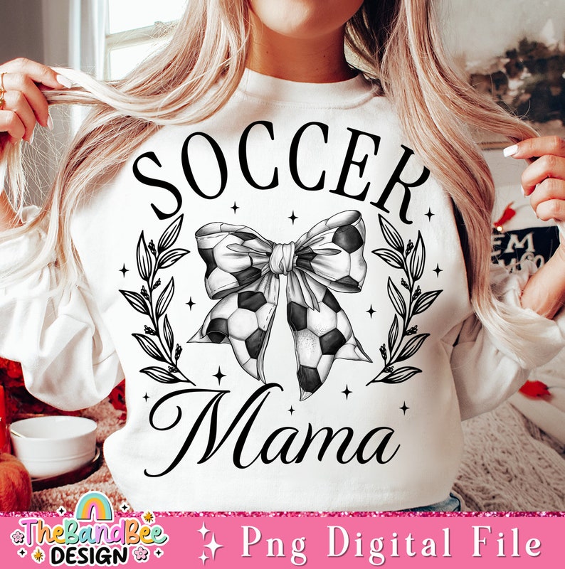 May include: White sweatshirt with black text that reads "Soccer Mama" and a black and white soccer ball bow with leaves and stars.