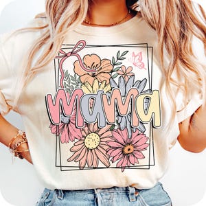 May include: A white t-shirt with a floral design and the word "mama" in pastel colors. The flowers are pink, yellow, and blue.