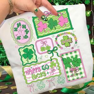 Op de afbeelding: Witte stof met diverse afbeeldingen met het thema St. Patrick's Day. Het ontwerp bevat klavers, strikken en de tekst "Happy Go Lucky" in roze en groen. De afbeeldingen zijn omlijst in groen en roze.