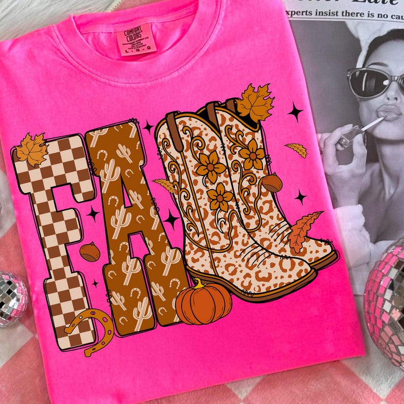 May include: Vibrant pink t-shirt with the word "FA" in a brown and tan checkered and cactus design. The letter "R" features cowboy boots with floral and leopard print. A pumpkin, horseshoe, and autumn leaves complete the design.