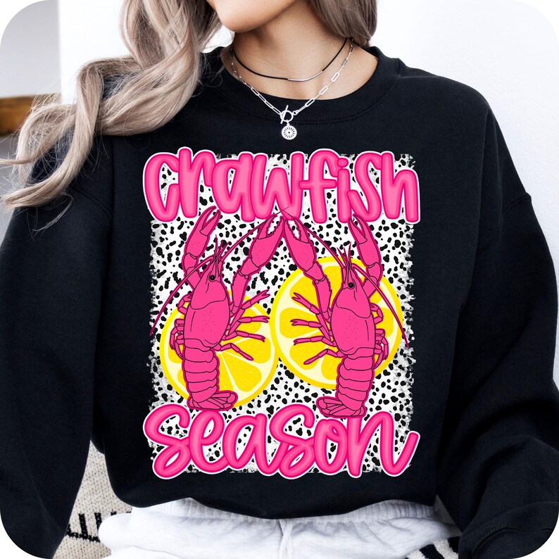 May include: Black sweatshirt with a pink graphic of two crawfish with lemons and the text "Crawfish Season".