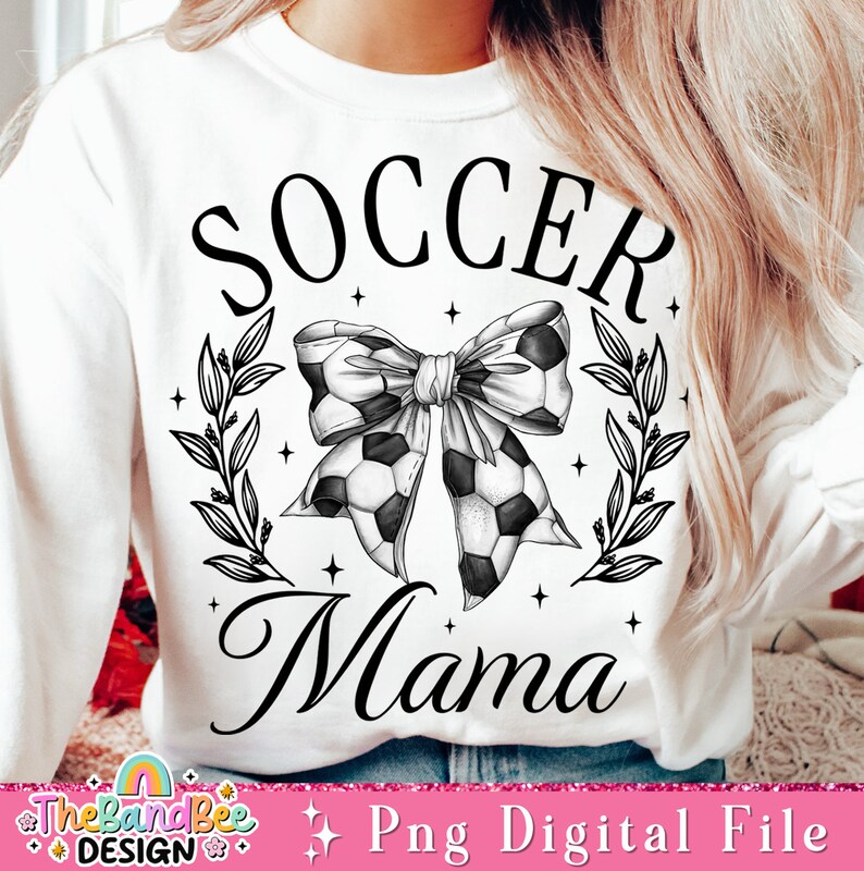 May include: Black and white graphic design of a soccer ball bow with leaves and stars. The text "Soccer Mama" is written below the bow.