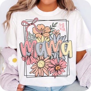 May include: White t-shirt with a floral design and the word "mama" in colorful letters. The flowers are pink, yellow, and orange.
