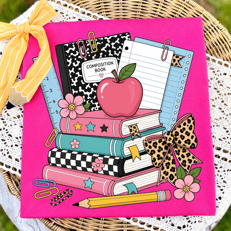 May include: A bright pink fabric featuring a graphic illustration of a stack of four books, a composition book, a red apple, a yellow pencil, a ruler, and colorful paper clips. A large leopard print bow and pink flowers decorate the school-themed design.