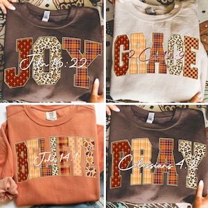 May include: Four crewneck sweatshirts in various colors, each featuring a different word: "JOY," "GRACE," "BELIEVE," and "PRAY." The words are designed with a mix of patterns, including leopard print, plaid, and cross motifs, along with corresponding Bible verses.