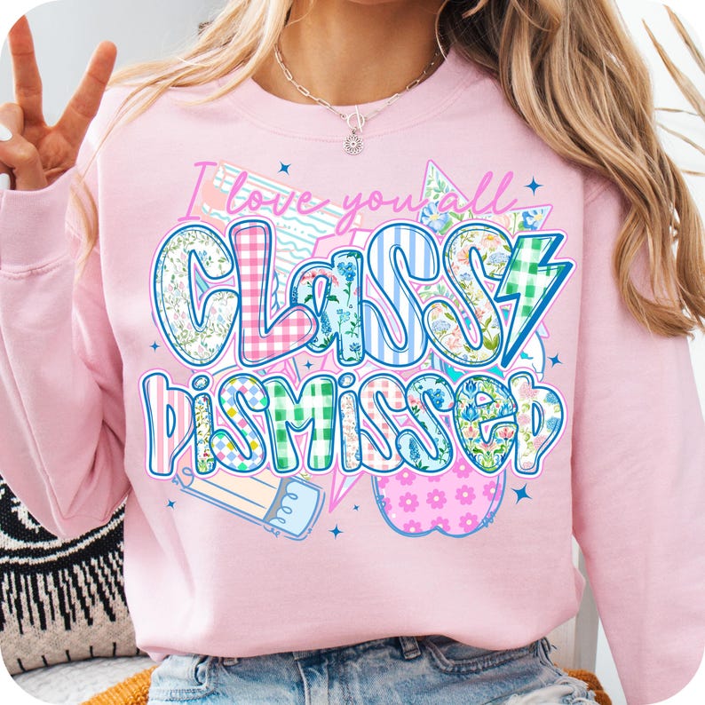 May include: Pink sweatshirt with the text "I love you all Classy Dismissed" in a colorful patchwork style. The text is surrounded by stars, a lightning bolt, a pencil, and an apple.