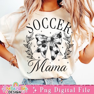 May include: A white t-shirt with a black graphic design that says "Soccer Mama" with a soccer ball bow and leaves.