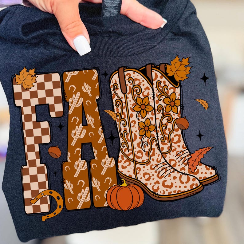 May include: Dark navy blue t-shirt with a colourful "FALL" graphic. The "F" is a brown and white chequered pattern, the "A" is decorated with cacti, and the "L" is decorated with cowboy boots, a pumpkin, and autumn leaves.