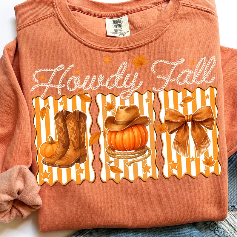 May include: Orange sweatshirt with the words "Howdy Fall" in white script. The design features illustrations of cowboy boots, a pumpkin with a cowboy hat, and a bow, all in a fall theme.