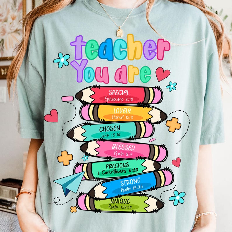 May include: A light blue t-shirt with the words "teacher You are" in colorful bubble letters. Below, stacked pencils display words like "Special" and "Unique" with Bible verses. Hearts and flowers decorate the design.