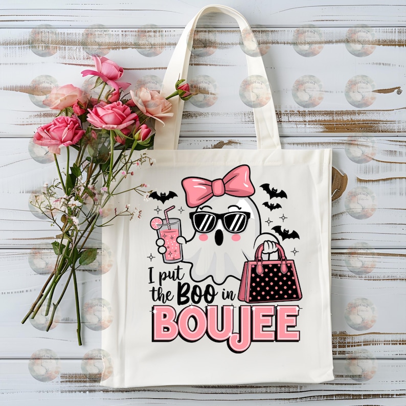 May include: White tote bag with a pink ghost wearing sunglasses and a pink bow holding a pink drink and a black and white polka dot purse. The text on the bag reads "I put the BOO in BOUJEE".