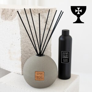 Puede incluir: Un difusor de piedra gris con cañas negras y una botella negra de aceite de difusor artesanal "sniff sniff" in vino veritas.
