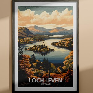 以下が含まれることがあります： スコットランドのロッホ・リーベンを描いた額入りアートプリント。秋色の木々、山々、曇り空に囲まれた湖の風景画です。プリントは黒いフレームで、「LOCH LEVEN SCOTLAND」の文字が入っています。
