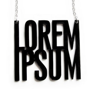 Puede incluir: Collar negro con un colgante que dice "LOREM IPSUM" en letras negritas y en bloque.