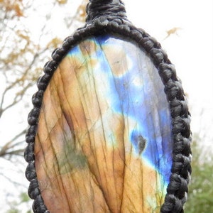 May include: A brown and blue labradorite gemstone pendant with a black cord.