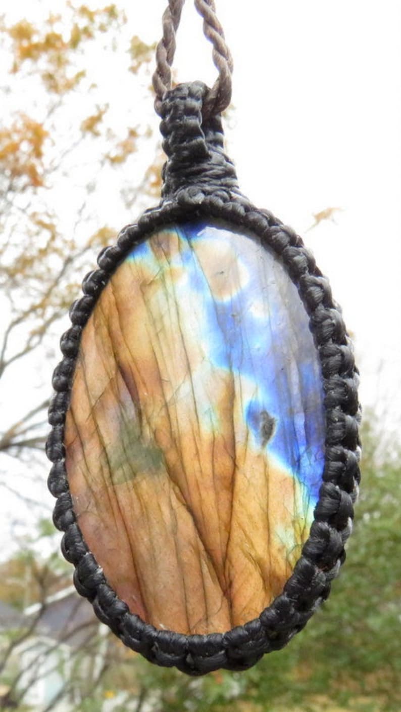 May include: A brown and blue labradorite gemstone pendant with a black cord.