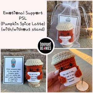 May include: Crocheted pumpkin spice latte cup with a cute face and a sign that says "You call it PSL, I call it my favorite season!" The cup is sitting on a small wooden stand.