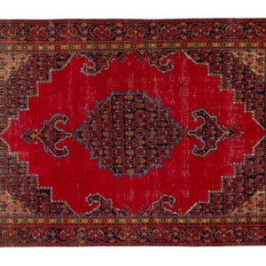 May include: A rectangular, vintage-style rug with a vibrant red central field. The rug features a detailed border with intricate patterns in shades of navy, gold, and brown. The central design includes a navy medallion and decorative elements.