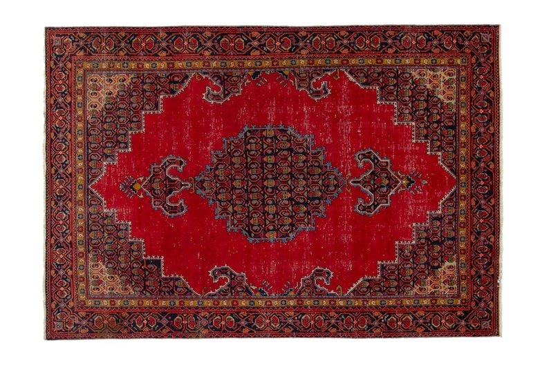 May include: A rectangular, vintage-style rug with a vibrant red central field. The rug features a detailed border with intricate patterns in shades of navy, gold, and brown. The central design includes a navy medallion and decorative elements.