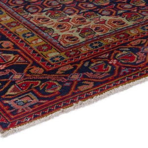 May include: Close-up of a section of a Persian rug with a detailed geometric pattern. The rug features a navy blue border with red and orange accents. The central design includes a mix of red, orange, and beige shapes.