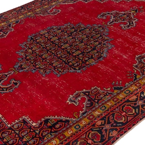 May include: A vibrant red area rug with intricate geometric patterns in navy blue, gold, and other colors. The rug features a central medallion design and ornate borders, showcasing a traditional aesthetic. The rug's distressed appearance adds to its vintage charm.