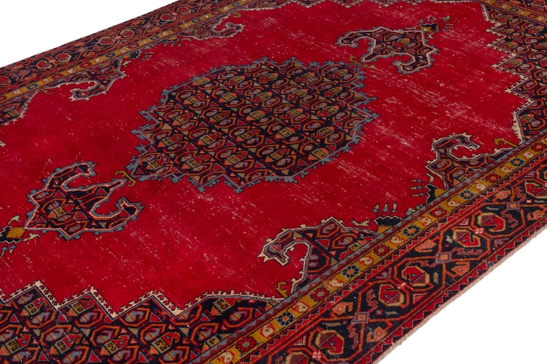 May include: A vibrant red area rug with intricate geometric patterns in navy blue, gold, and other colors. The rug features a central medallion design and ornate borders, showcasing a traditional aesthetic. The rug's distressed appearance adds to its vintage charm.