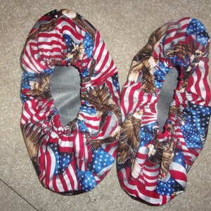 May include: A pair of red, white, and blue shoe covers with an American flag and eagle print.