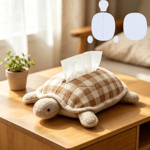 Puede incluir: Una funda para caja de pañuelos con forma de tortuga hecha de tela de cuadros vichy beige y marrón con lunares blancos en la cabeza y las extremidades. Un pañuelo blanco sale por la abertura central. Un diagrama del patrón es visible arriba.
