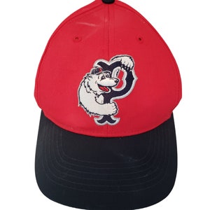 May include: Red and black baseball cap with a white polar bear wearing a hat and holding a letter P.
