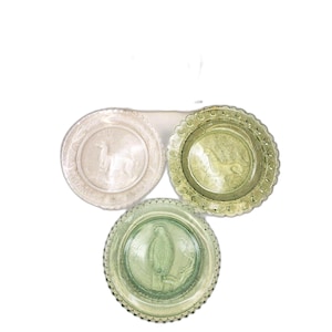 May include: Three decorative plates with embossed animal designs. The plates are in shades of white and green, featuring a deer, a lion, and a bird. Each plate has a scalloped edge, adding a touch of elegance to the design.