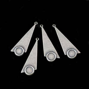 May include: Five silver-toned metal triangle-shaped charms with a round hole at the top and a circular cutout at the bottom.
