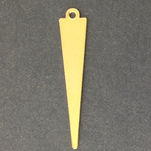 May include: A gold-colored metal pendant shaped like a long, narrow triangle with a rounded top and a hole for stringing.