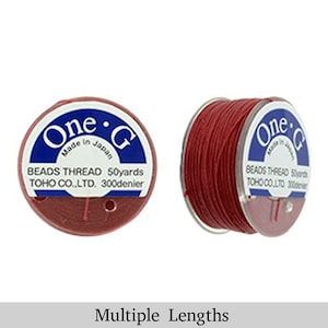 May include: Red beading thread spool labeled "One-G Made in Japan Beads Thread 50yards TOHO CO.,LTD. 300denier"