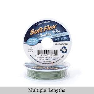 Op de afbeelding: Een spoel groene Soft Flex kralendraad, met het label "Fluorite Color" en "Medium". Het label vermeldt ook "Original Flex Wire", "Knot Tying Stainless Steel Nylon Coated", "Test Strength 26 lbs.", "All Purpose - Glass, Mineral & Metal Beads", "Diameter .019 in. (.48mm)", "Length 10 ft. (3.05m)", "49 Strands", en "Made in the USA".