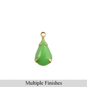 May include: A green glass teardrop charm with gold accents. The charm has a loop at the top for attaching to jewelry.