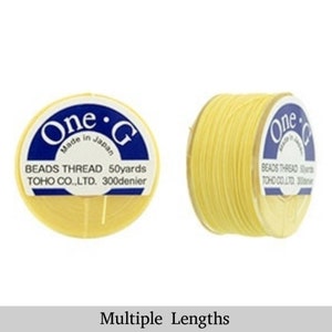 May include: A spool of yellow One-G Beads Thread, made in Japan, by TOHO CO., LTD. The spool is labeled with the text "One-G Beads Thread 50yards TOHO CO.,LTD. 300denier".