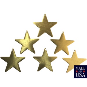 May include: Six gold-toned metal star-shaped ornaments. The stars are arranged in a triangular pattern. The text "MADE IN THE USA" is visible in the bottom right corner of the image.