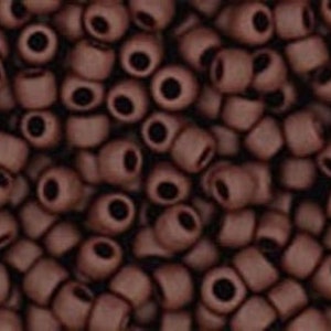 May include: A close-up image of a pile of small, dark brown seed beads. The beads are round and have a matte finish.