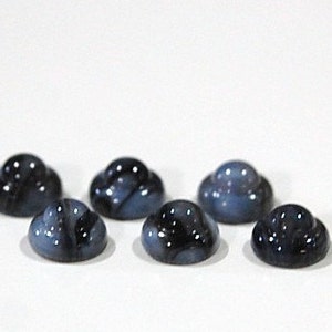 Könnte beinhalten: Sechs kleine, runde, blaue und schwarze Glascabochons. Die Cabochons haben eine gewölbte Form und sind in einer Reihe angeordnet.