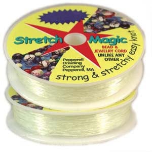 Op de afbeelding: Een spoel met transparante Stretch Magic Bead & Jewelry Cord. Het etiket vermeldt "Stretch Magic Bead & Jewelry Cord Unlike Any Other Strong & Stretchy Easy Knot Pepperell Braiding Company Pepperell, MA".