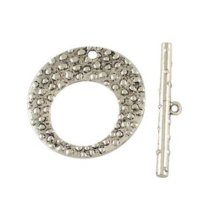 May include: Silver-toned metal toggle clasp with a textured round loop and a straight bar. The loop has a textured surface with small raised dots.