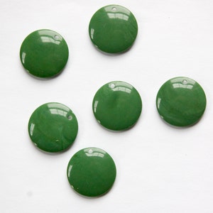 May include: Six green round sequins with a hole in the centre. The sequins are shiny and have a slight marbled effect.