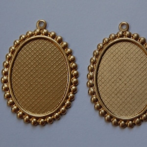 May include: Two gold oval-shaped metal pendant frames with a textured surface and a beaded border.