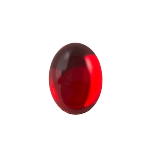 May include: A smooth, oval-shaped cabochon gemstone in a deep, translucent red color. The stone features a polished, reflective surface with varying shades of crimson and scarlet, showing light refraction and internal depth throughout the piece.