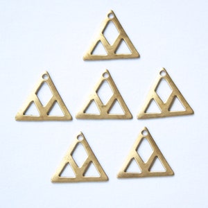 Puede incluir: Seis abalorios de metal de color dorado en forma de triángulo con un diseño geométrico. Cada abalorio tiene un pequeño agujero en la parte superior para sujetarlo a joyas u otras manualidades.